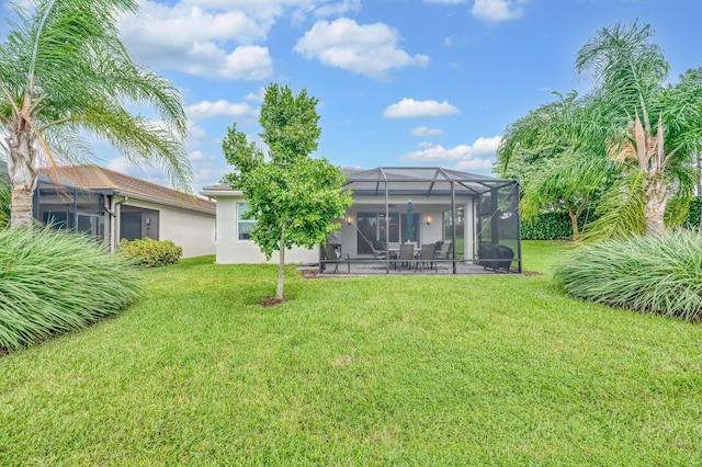 rear view of property featuring a patio, glass enclosure, and a lawn