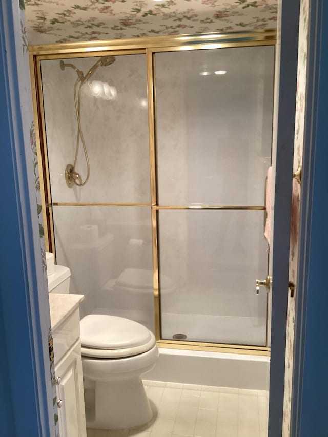 bathroom featuring vanity, toilet, tile patterned floors, and a shower with door