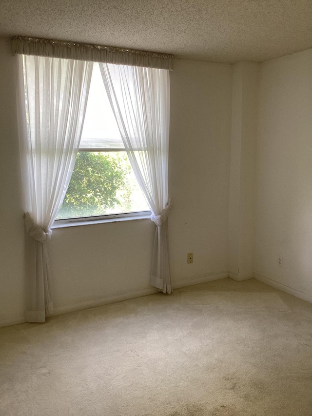 carpeted spare room featuring a textured ceiling