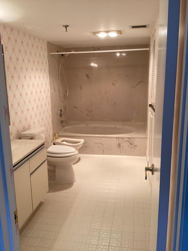 full bathroom featuring bathtub / shower combination, toilet, vanity, a bidet, and tile patterned flooring