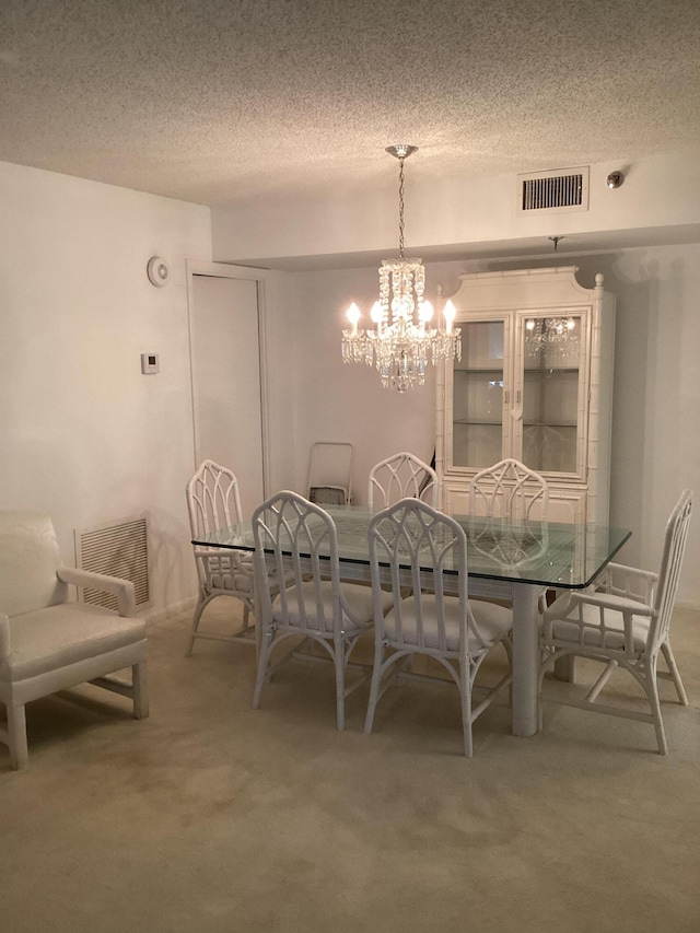 dining space with carpet, a textured ceiling, and an inviting chandelier