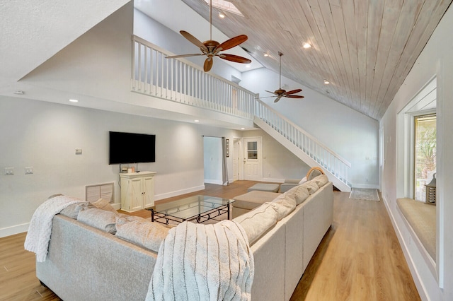 living room featuring ceiling fan, light hardwood / wood-style flooring, high vaulted ceiling, and wooden ceiling