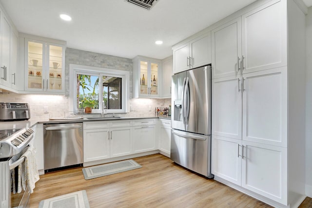 kitchen featuring white cabinets, stainless steel appliances, and light hardwood / wood-style floors