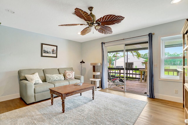 living room with light hardwood / wood-style floors and ceiling fan