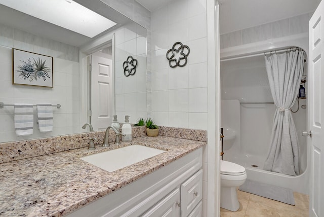 bathroom with vanity, curtained shower, tile patterned floors, tile walls, and toilet