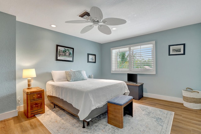 bedroom with ceiling fan, a textured ceiling, and light wood-type flooring