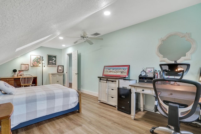 bedroom with lofted ceiling, light hardwood / wood-style floors, ceiling fan, and a textured ceiling