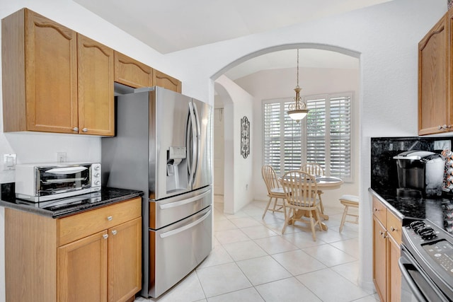 kitchen with vaulted ceiling, stainless steel appliances, light tile patterned floors, and pendant lighting