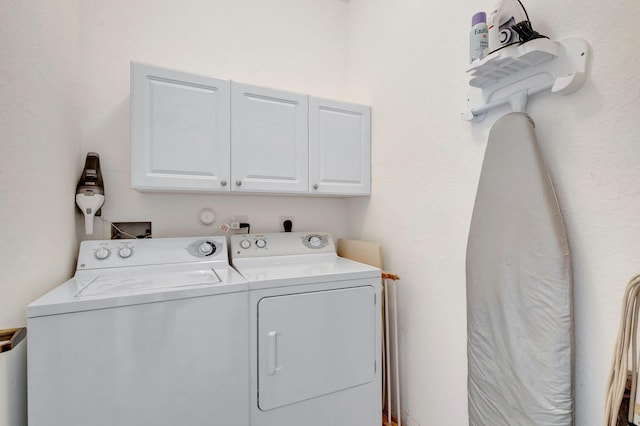 laundry area featuring washer and dryer and cabinets