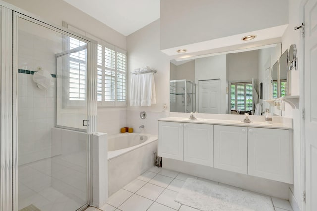 bathroom with vanity, independent shower and bath, a wealth of natural light, and tile patterned flooring