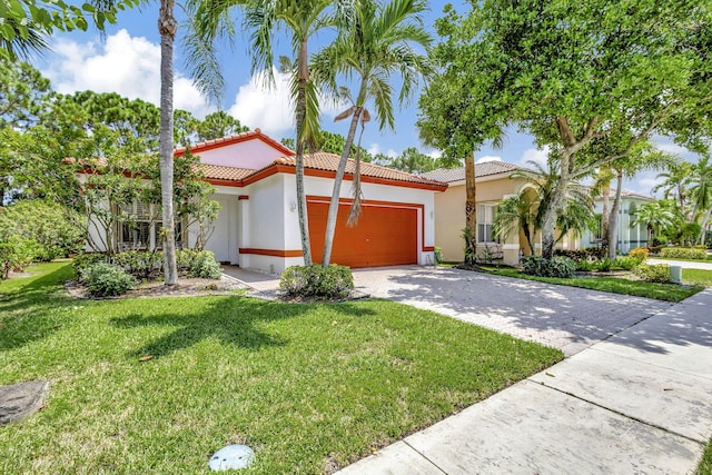 mediterranean / spanish-style house featuring a front yard and a garage