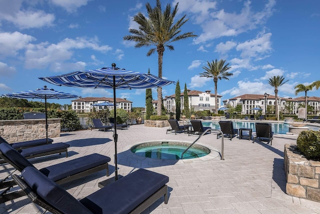 view of swimming pool featuring a hot tub and a patio area