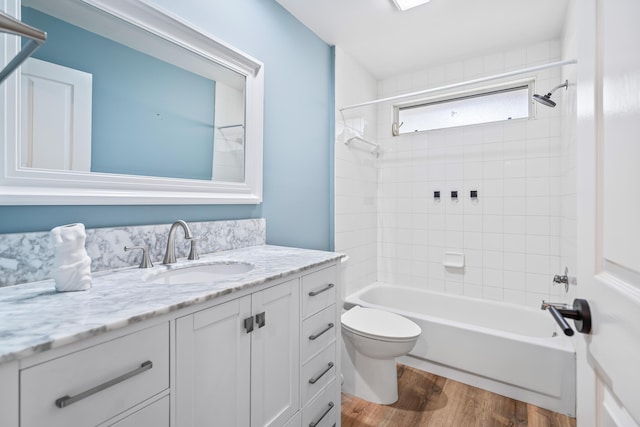 bathroom featuring toilet, shower / bath combination, wood finished floors, and vanity