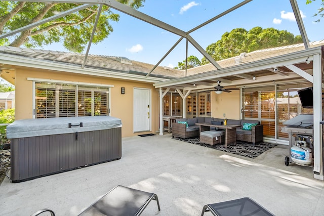 view of patio / terrace with outdoor lounge area, a lanai, a ceiling fan, and a hot tub