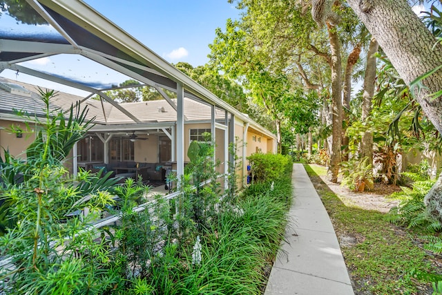 view of yard with a lanai and ceiling fan