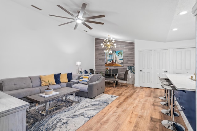 living room with recessed lighting, visible vents, light wood-style flooring, high vaulted ceiling, and ceiling fan with notable chandelier