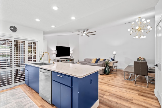 kitchen with open floor plan, a sink, wood finished floors, blue cabinets, and dishwasher