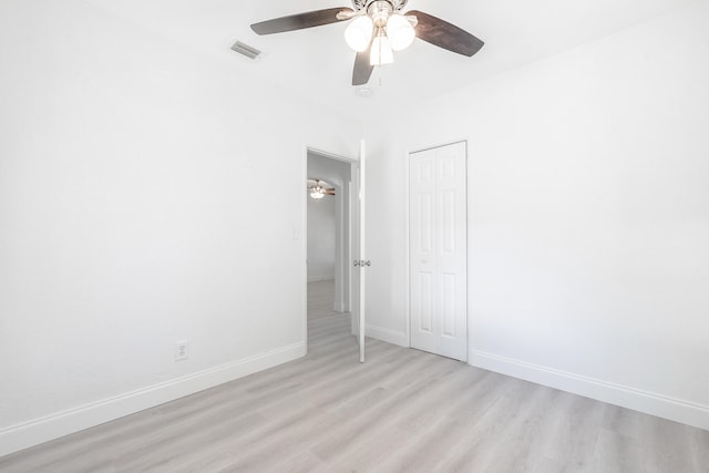 unfurnished bedroom with light hardwood / wood-style flooring, a closet, and ceiling fan