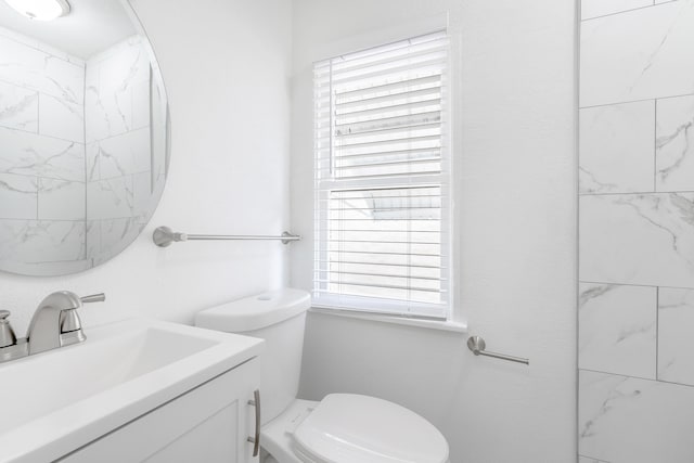 bathroom with a wealth of natural light, vanity, and toilet