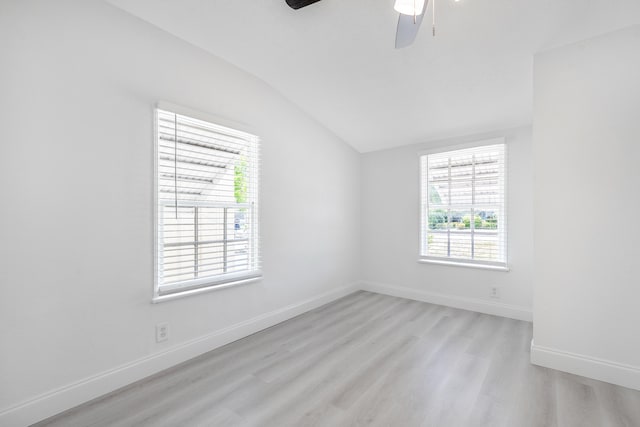 spare room featuring lofted ceiling, light wood-type flooring, and ceiling fan