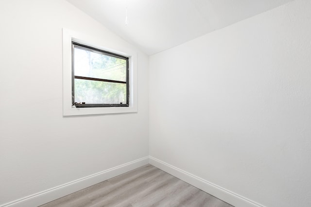 unfurnished room with hardwood / wood-style flooring and vaulted ceiling