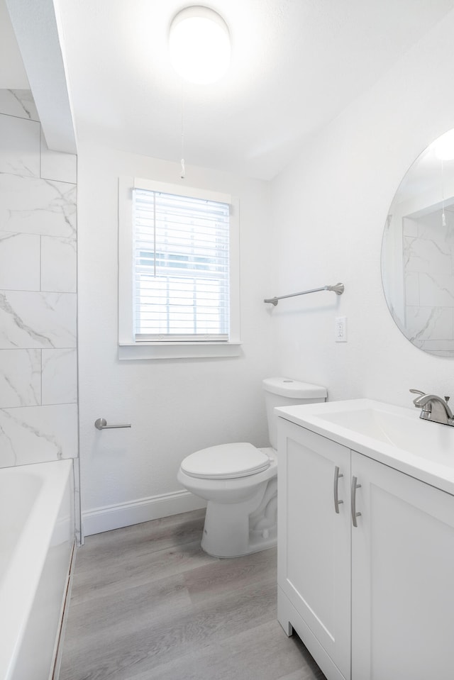 full bathroom featuring vanity, toilet, tiled shower / bath, and hardwood / wood-style flooring