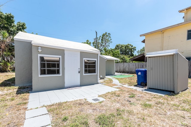 rear view of house with a patio area and a storage shed