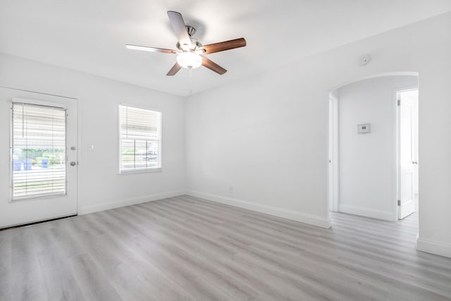 empty room with ceiling fan and light hardwood / wood-style flooring