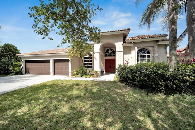 mediterranean / spanish house with a garage and a front yard