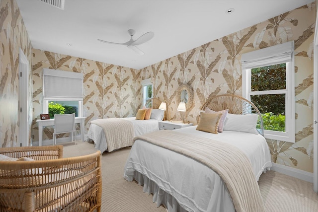 carpeted bedroom featuring wallpapered walls, baseboards, and a ceiling fan