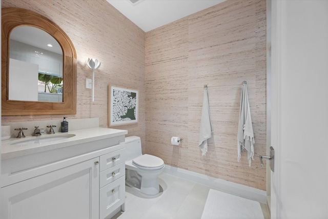 bathroom featuring vanity, toilet, tile walls, and tile patterned floors