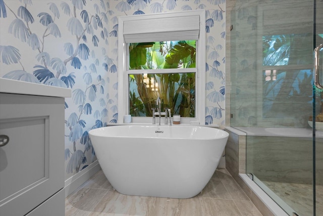 bathroom with wallpapered walls, a soaking tub, and a shower stall