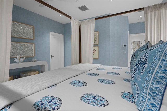 bedroom featuring visible vents and wallpapered walls