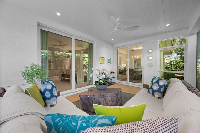 exterior space featuring wood finished floors, a textured wall, recessed lighting, wooden ceiling, and ceiling fan with notable chandelier