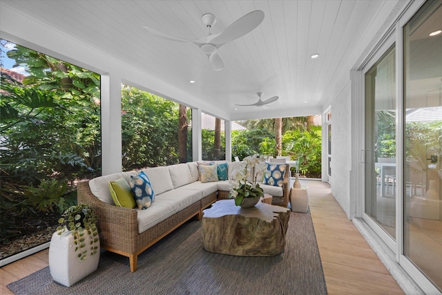 sunroom / solarium with wood ceiling, a ceiling fan, and a wealth of natural light