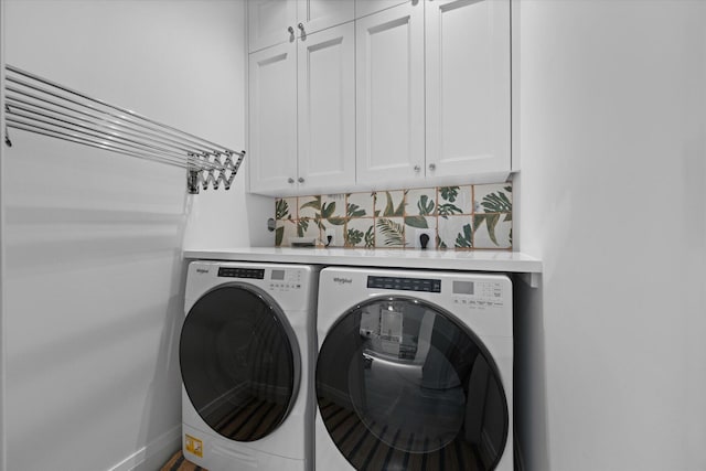 washroom featuring washer and dryer and cabinets