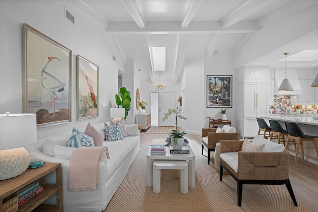 living room with light wood-type flooring and lofted ceiling with beams