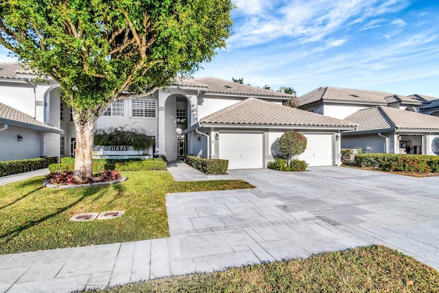 mediterranean / spanish-style house with a garage and a front lawn