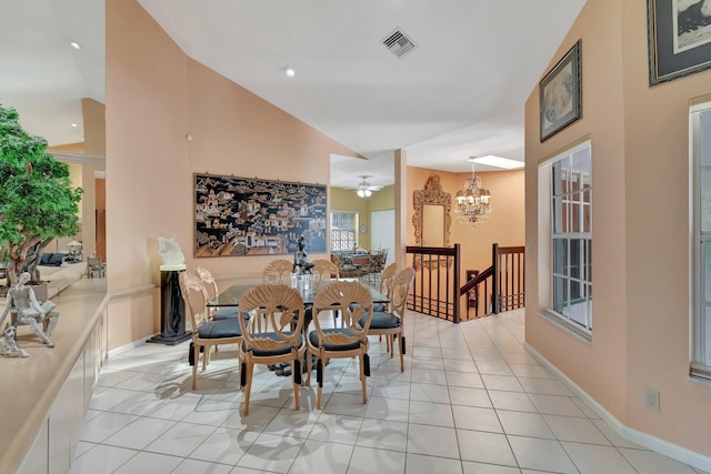 tiled dining area with vaulted ceiling and ceiling fan with notable chandelier