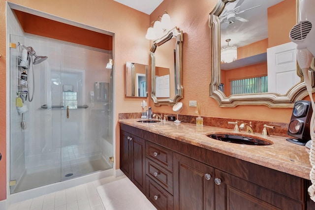 bathroom with a shower with door, vanity, tile patterned flooring, and ceiling fan