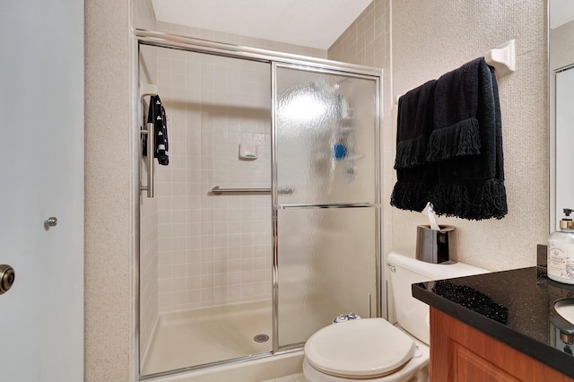 bathroom with vanity, a shower with shower door, and toilet