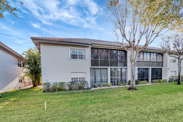 rear view of property featuring a lawn