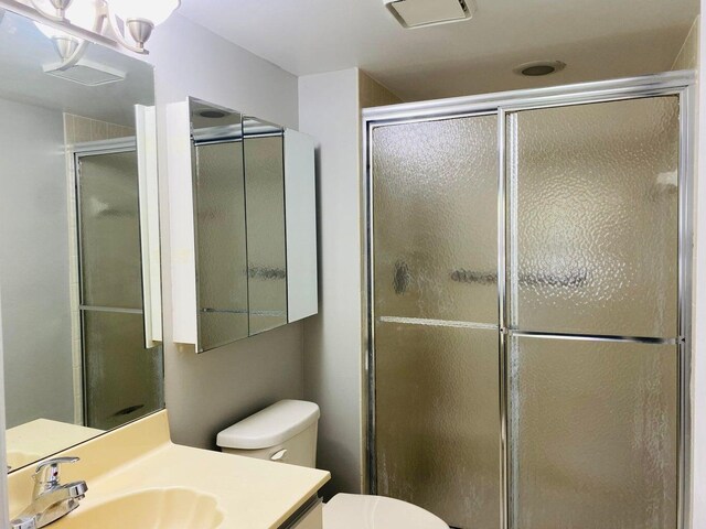 bathroom with vanity, walk in shower, and toilet