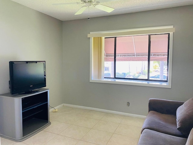 sitting room featuring baseboards, a textured ceiling, ceiling fan, and light tile patterned flooring