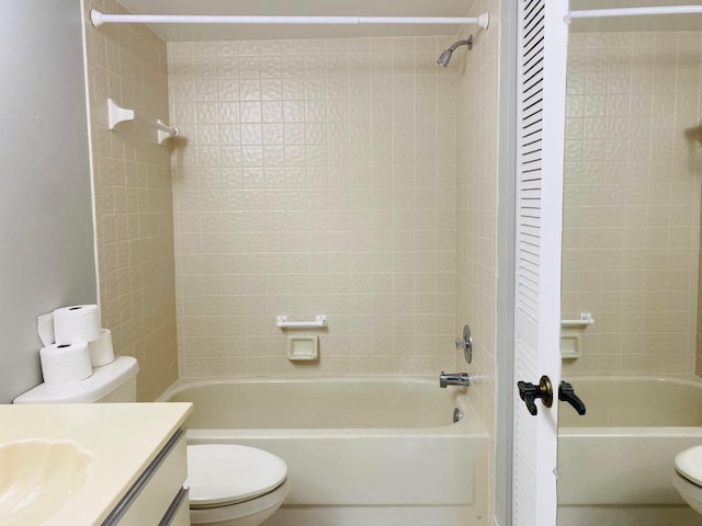 full bathroom featuring toilet, tiled shower / bath combo, and vanity