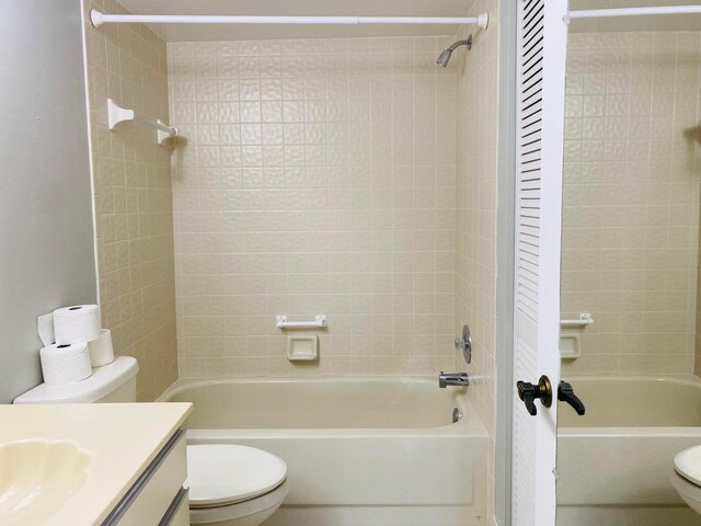 bathroom featuring vanity, bathing tub / shower combination, and toilet