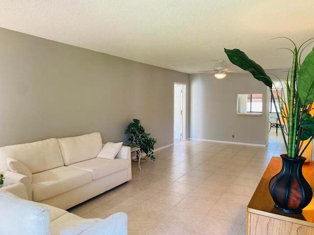 living room featuring a textured ceiling, light tile patterned floors, and ceiling fan