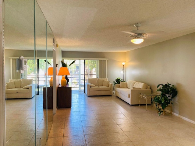 tiled living room with ceiling fan and a textured ceiling