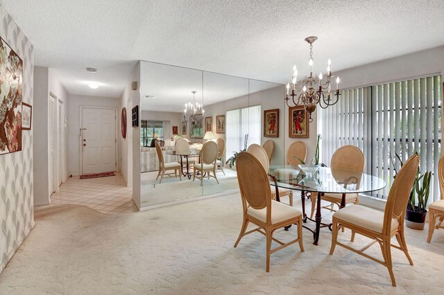 carpeted dining room featuring a chandelier and a textured ceiling