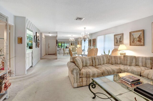 carpeted living room featuring an inviting chandelier and a textured ceiling